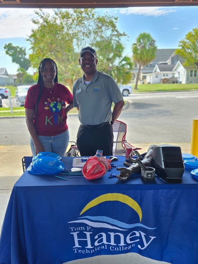 K.I.N. volunteer with a representative at the Haney Technical College table