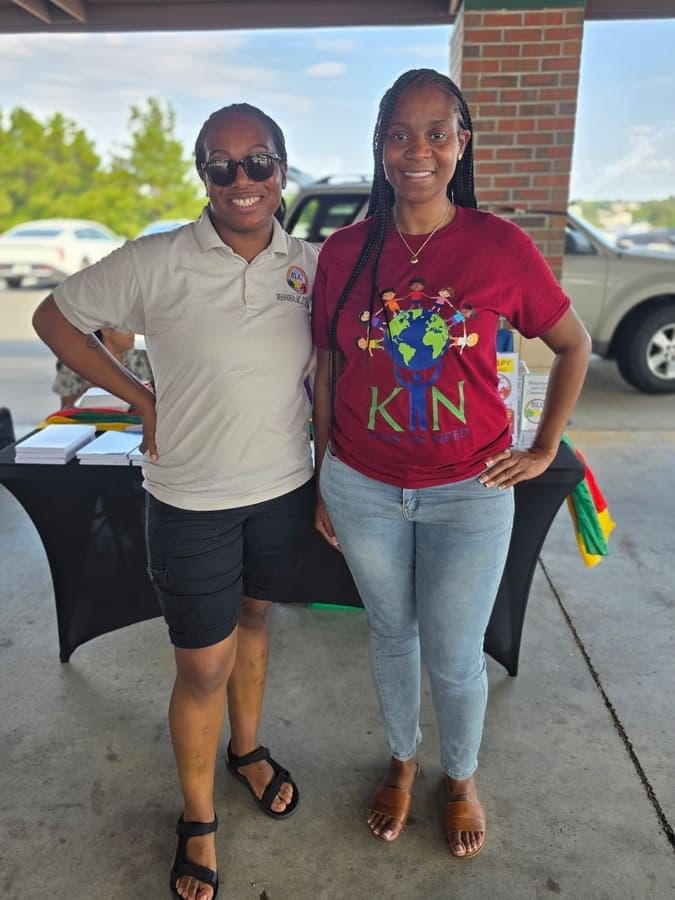 K.I.N. volunteer and a community partner at an outreach table