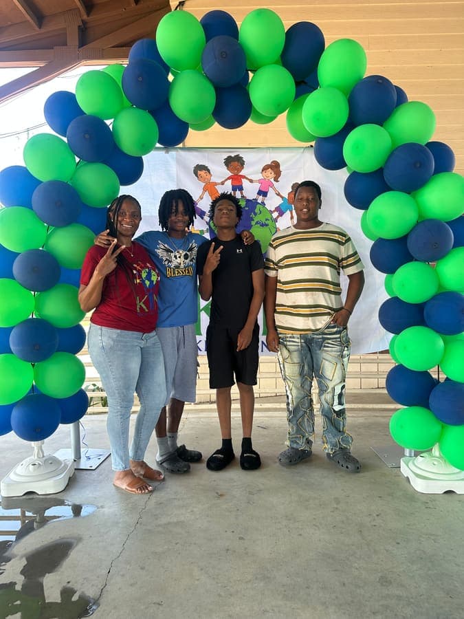 Group of youth posing under the balloon arch