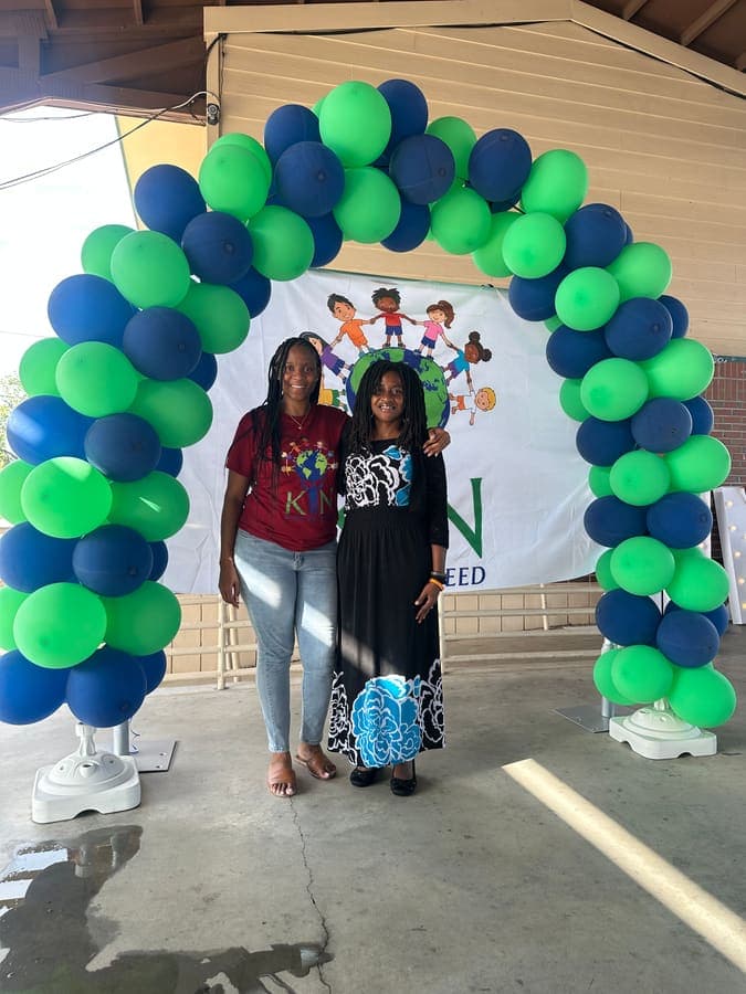 Two guests posing under the balloon arch