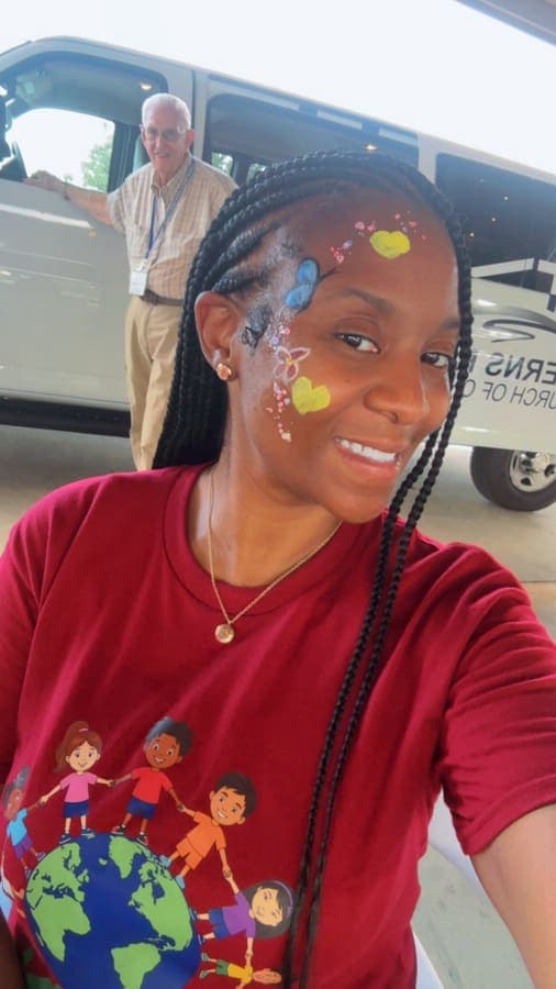 K.I.N. volunteer with face paint taking a selfie
